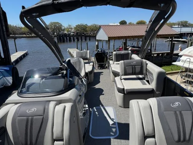 Slide: The Image of 2025 Barletta CORSA 25MA pontoon boat with luxurious seating, docked by a serene waterfront. - 20