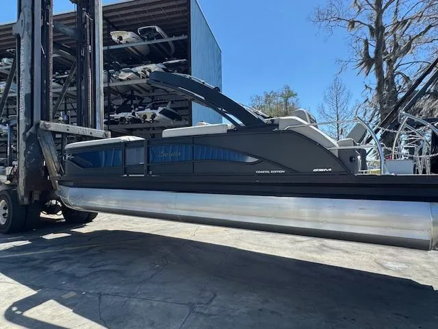 Slide: The Image of 2025 Barletta CORSA 25MA pontoon boat on forklift, outdoor storage facility. - 3