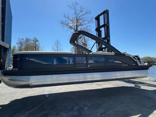 Slide: The Image of 2025 Barletta CORSA 25MA pontoon boat on a lift, under clear blue sky. - 5