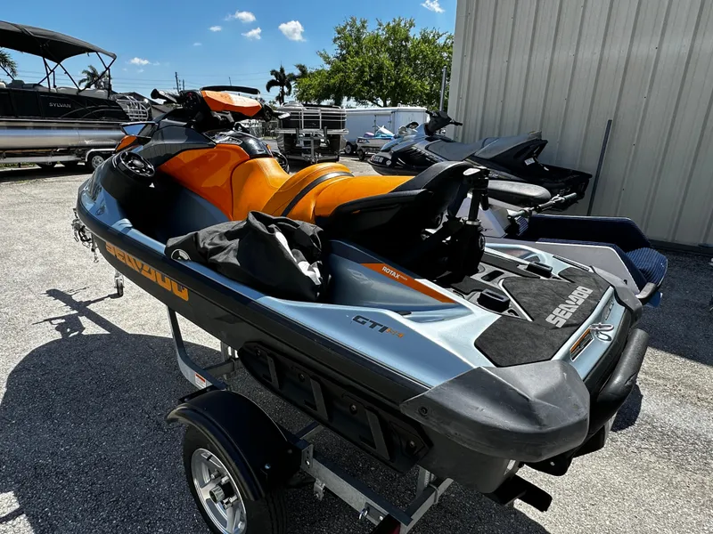Slide: The Image of 2020 Sea-Doo GTI SE 130 jet ski on trailer, orange and black, parked outdoors. - 3