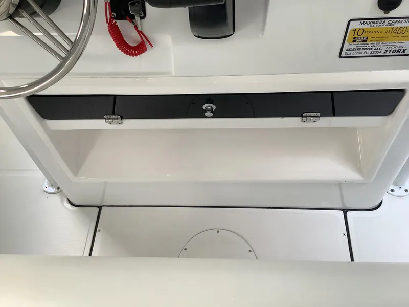 Slide: The Image of 2025 Release 210RX Center Console interior with steering wheel and storage compartment. - 14