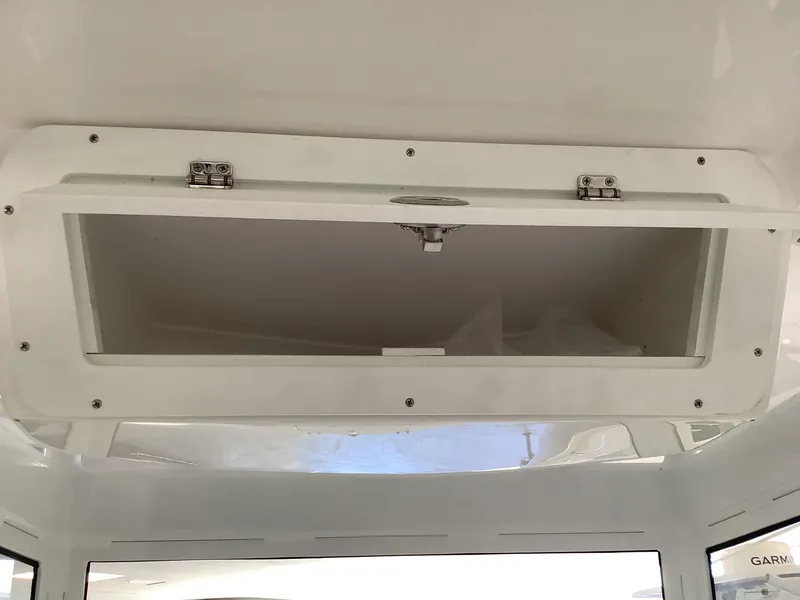 Slide: The Image of 2025 Release 210RX Center Console storage compartment, open and empty, with white interior. - 16