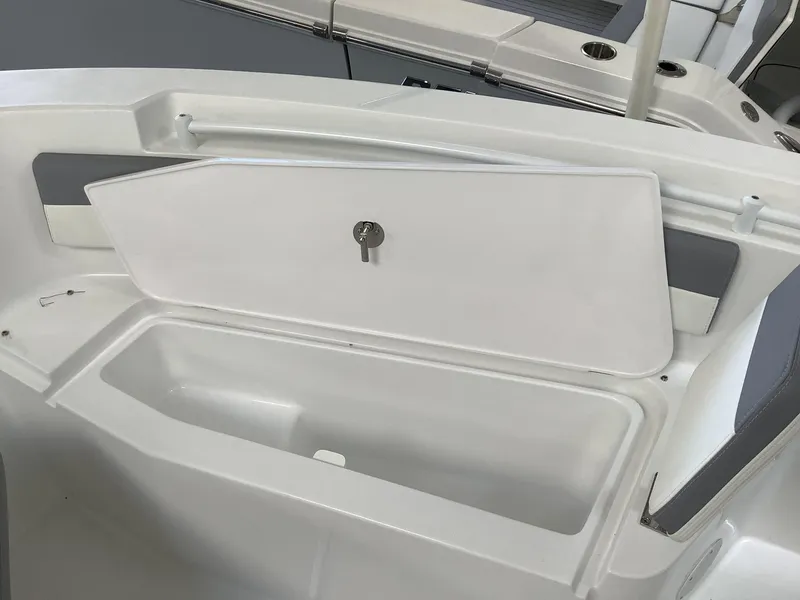 Slide: The Image of 2025 Release 210RX Center Console boat storage compartment with open lid. - 22