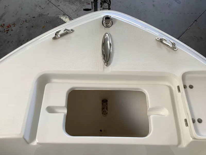 Slide: The Image of 2025 Release 210RX Center Console boat deck with storage compartment and cleats. - 24