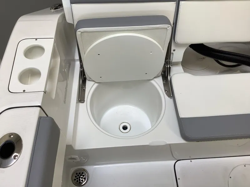 Slide: The Image of 2025 Release 210RX Center Console boat interior with cup holders and storage compartment. - 27
