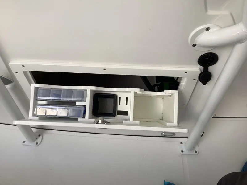 Slide: The Image of 2025 Release 210RX Center Console storage compartment with organized tackle boxes and utility space. - 28