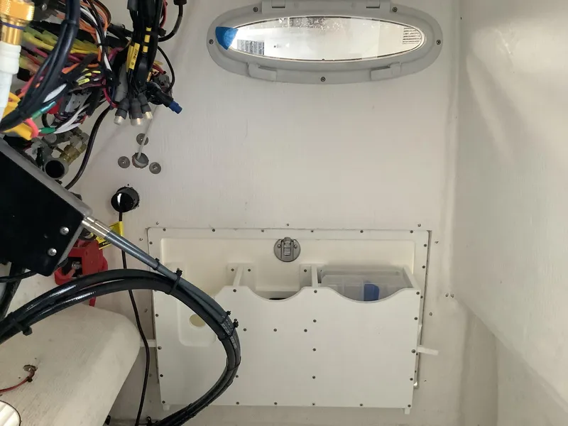 Slide: The Image of Interior view of 2025 Release 210RX Center Console boat, showcasing wiring and storage compartment. - 30