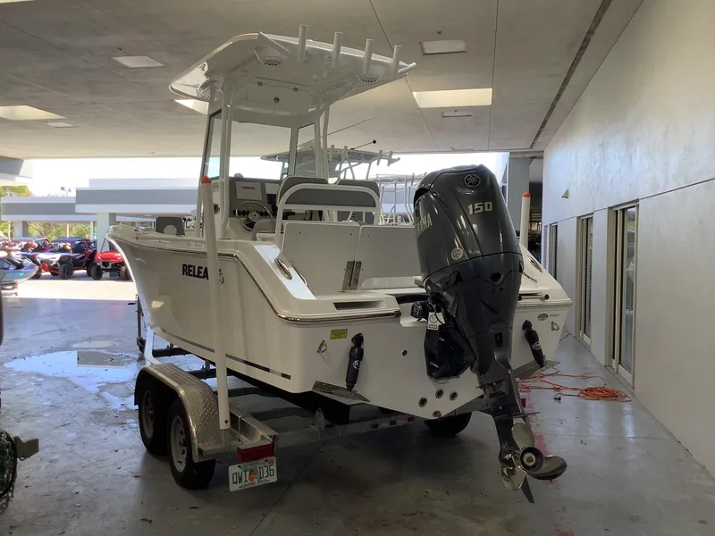 Slide: The Image of 2025 Release 210RX Center Console boat with 150HP engine in a garage setting. - 5