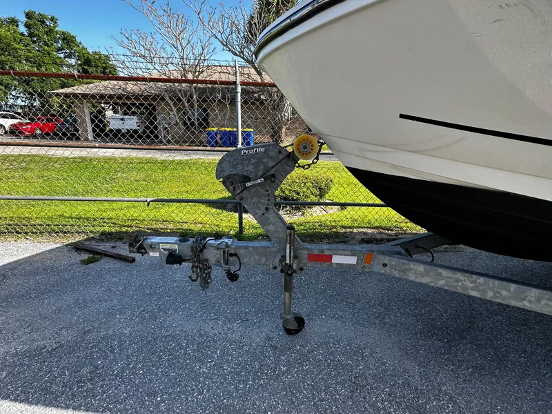 Slide: The Image of 2021 Bayliner VR6 Bowrider OB on trailer, parked near chain-link fence. - 2