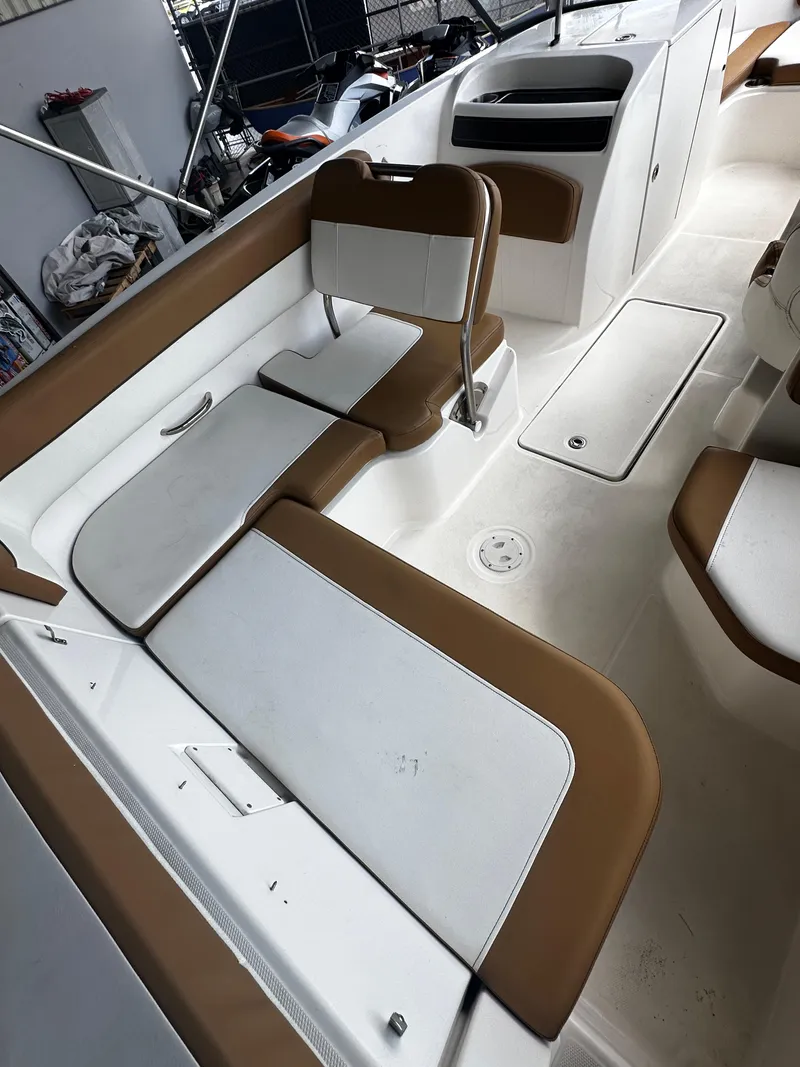 Slide: The Image of 2021 Bayliner VR6 Bowrider OB interior with brown and white seating arrangement. - 21