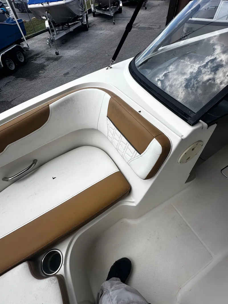 Slide: The Image of 2021 Bayliner VR6 Bowrider OB interior with tan and white seating, cup holder, and windshield. - 26