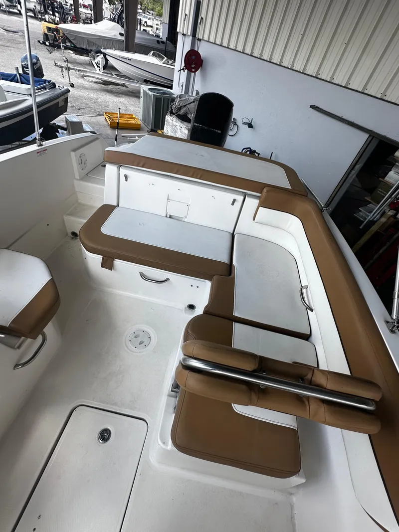 Slide: The Image of 2021 Bayliner VR6 Bowrider OB interior with tan seating in a showroom. - 30