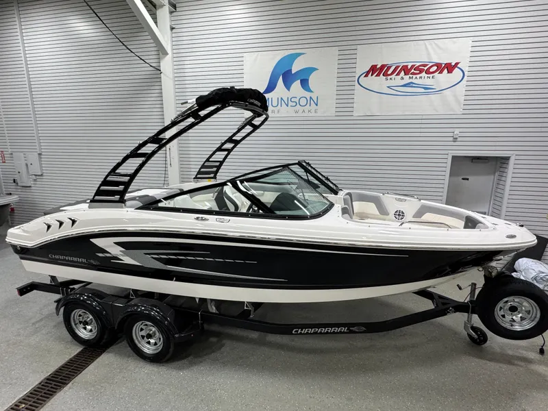Slide: The Image of 2025 Chaparral 21 SSi boat in showroom, black and white exterior, on trailer. - 2