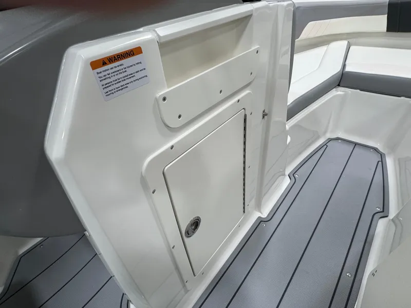 Slide: The Image of 2025 Chaparral 21 SSi boat storage compartment with sleek white finish and secure latch. - 22