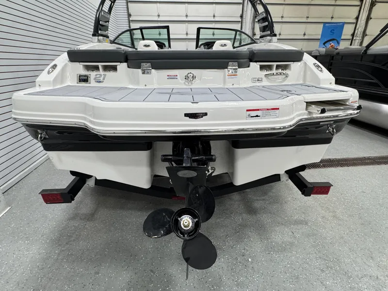 Slide: The Image of 2025 Chaparral 21 SSi boat rear view in showroom, showcasing propeller and swim platform. - 4