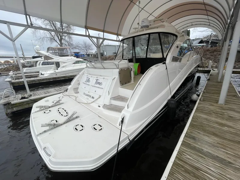 Slide: The Image of 2008 Sea Ray 550 Sundancer docked under a canopy, showcasing sleek design and spacious deck. - 11