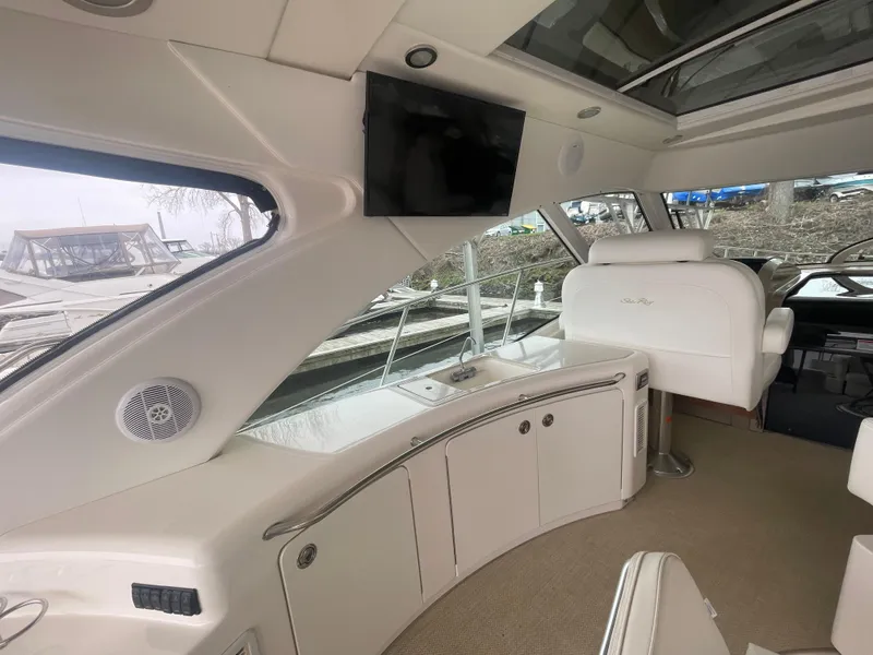 Slide: The Image of 2008 Sea Ray 550 Sundancer interior with sleek design, featuring a TV and comfortable seating. - 24