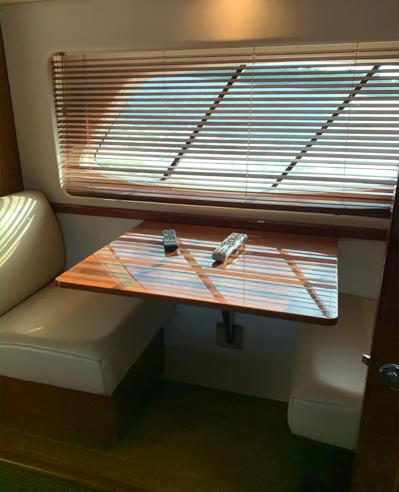 Slide: The Image of Interior of 2008 Sea Ray 550 Sundancer with wooden table and cushioned seating. - 50