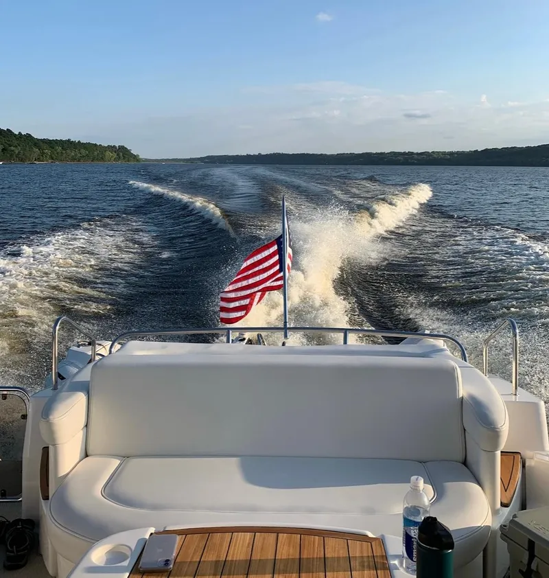 Slide: The Image of 2008 Sea Ray 550 Sundancer cruising with American flag, scenic water view. - 7