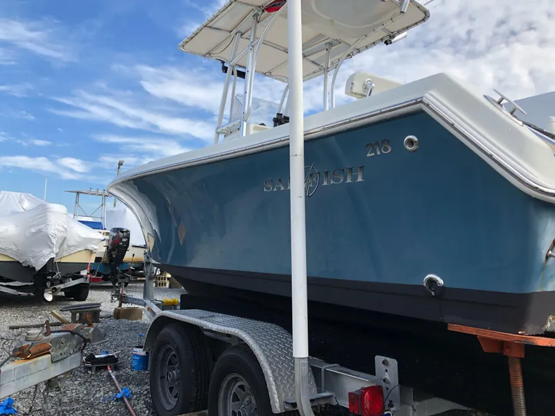 Slide: The Image of 2009 Sailfish 218 CC boat on trailer, blue hull, clear sky background. - 15