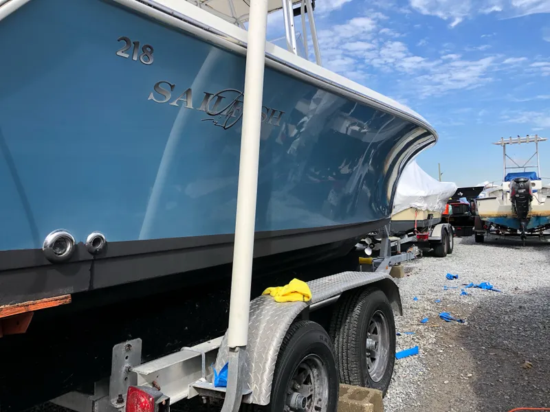 Slide: The Image of 2009 Sailfish 218 CC boat on trailer, blue hull, parked outdoors. - 16