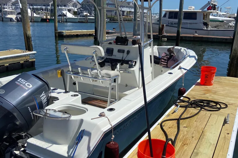 Slide: The Image of 2009 Sailfish 218 CC boat docked, featuring Yamaha 150 engine, in a marina setting. - 18