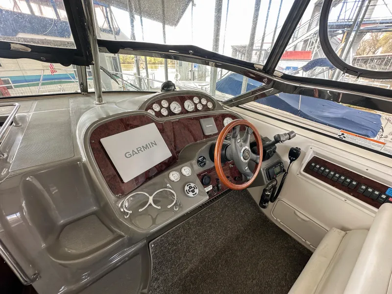 Slide: The Image of 2007 Regal Commodore 3760 IO helm with Garmin navigation, wood-trimmed steering, and control panel. - 10