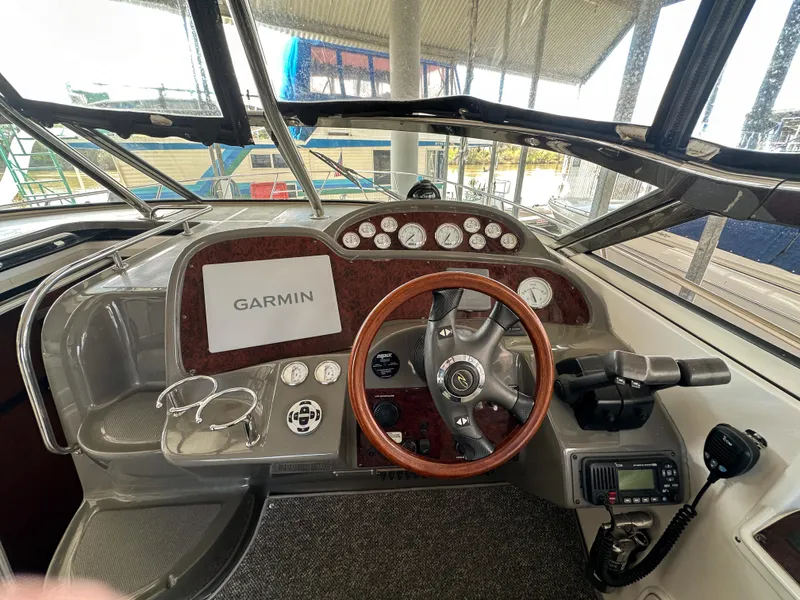 Slide: The Image of 2007 Regal Commodore 3760 IO boat dashboard with Garmin navigation system and wood-trimmed steering wheel. - 11