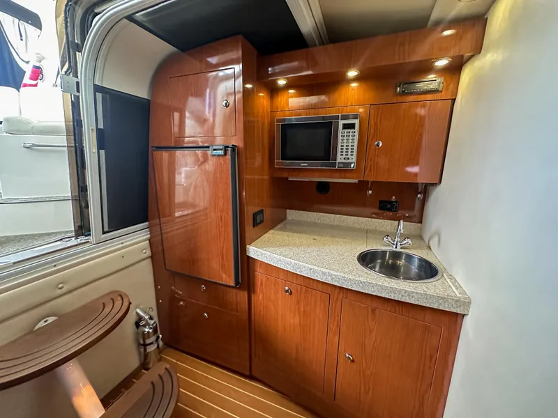 Slide: The Image of 2007 Regal Commodore 3760 IO yacht kitchen with wood cabinets, microwave, and sink. - 15