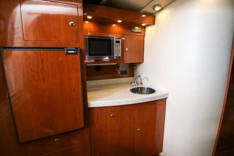 Slide: The Image of 2007 Regal Commodore 3760 IO yacht kitchen with wood cabinets, microwave, and sink. - 16