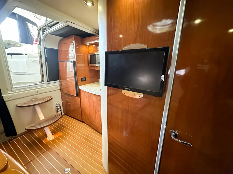 Slide: The Image of 2007 Regal Commodore 3760 IO interior with wood finish, TV, and kitchenette. - 21