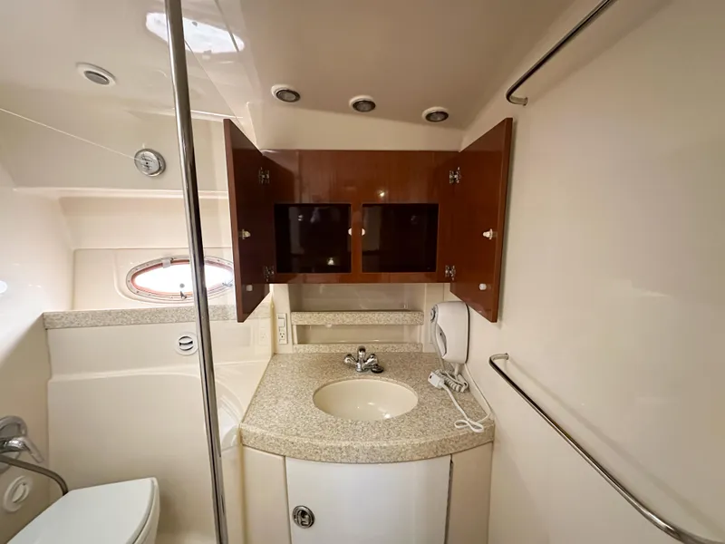 Slide: The Image of 2007 Regal Commodore 3760 IO yacht bathroom with sink, mirror, and storage cabinets. - 27