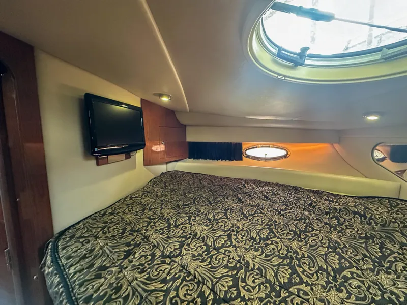 Slide: The Image of 2007 Regal Commodore 3760 IO cabin interior with bed, TV, and porthole windows. - 34
