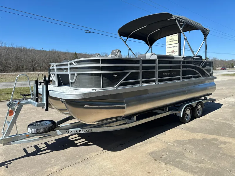 Slide: The Image of 2025 Bennington 22 SF pontoon boat on trailer, parked outdoors. - 2