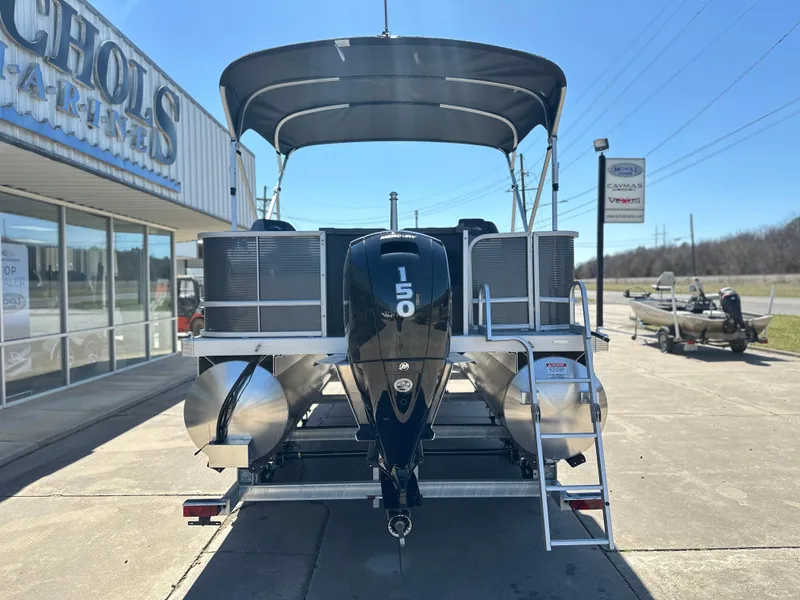 Slide: The Image of 2025 Bennington 22 SF pontoon boat with 150 HP engine, parked outside dealership. - 3
