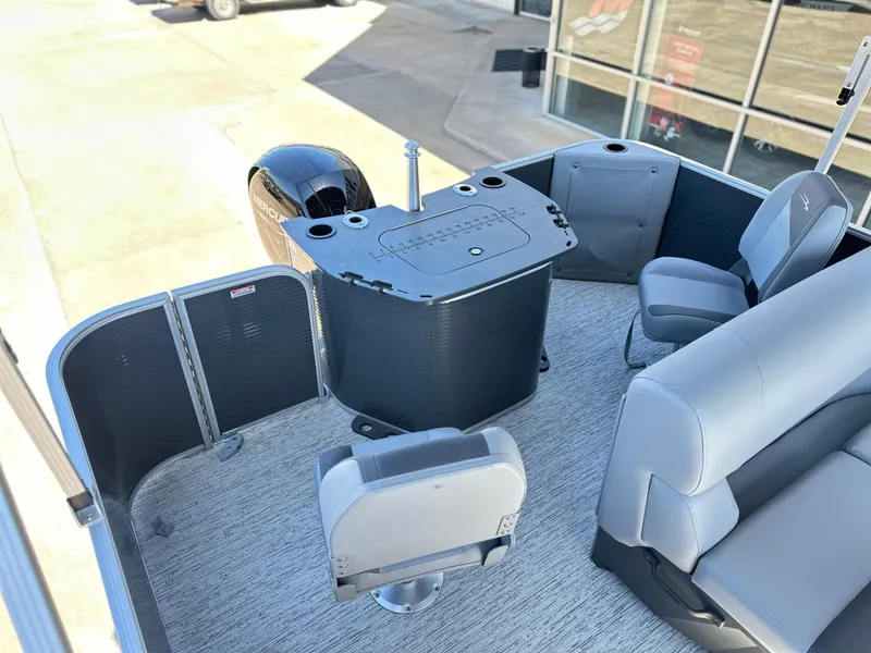Slide: The Image of 2025 Bennington 22 SF boat interior with seating and motor, docked near a building. - 8