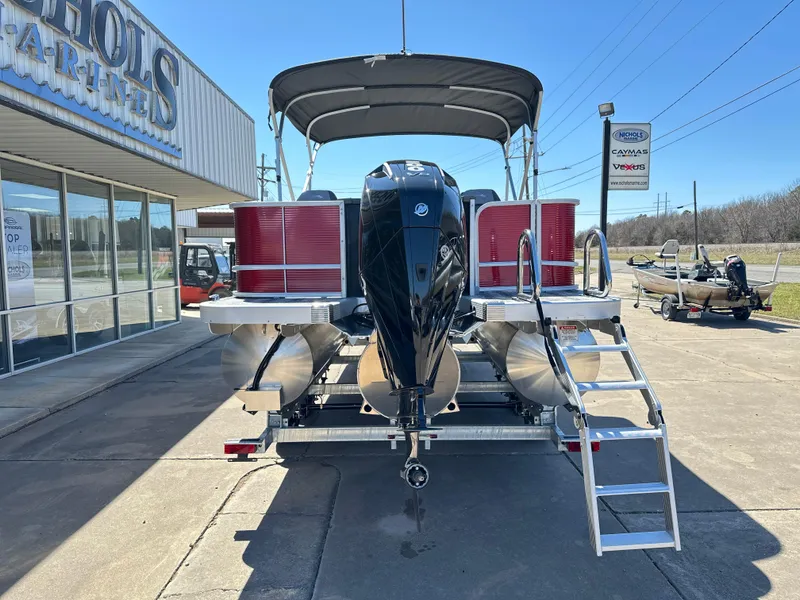Slide: The Image of 2025 Bennington 23 SF pontoon boat with outboard motor and ladder, parked outside dealership. - 3