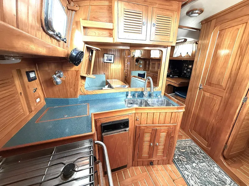 Slide: The Image of Luxurious 2000 Cabo Rico Pearl Edition yacht interior with wooden cabinetry and modern amenities. - 14