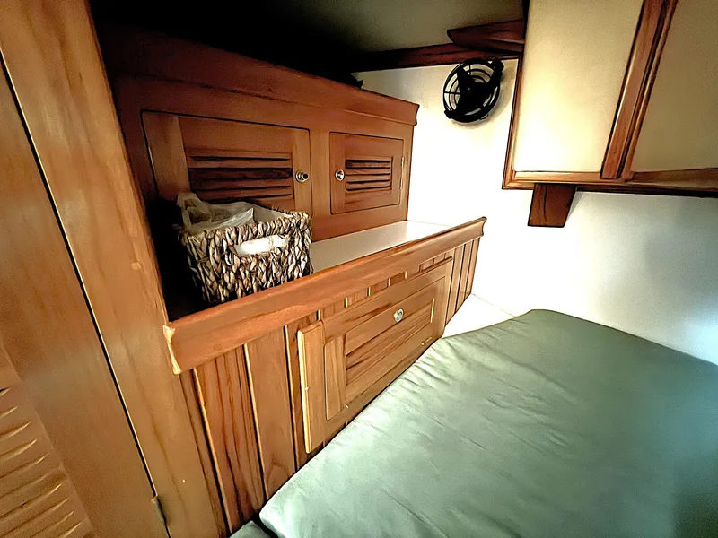 Slide: The Image of Interior of 2000 Cabo Rico Pearl Edition yacht with wooden cabinetry and cozy sleeping area. - 22