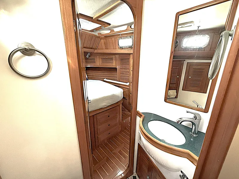 Slide: The Image of Interior of 2000 Cabo Rico Pearl Edition yacht, featuring wooden cabinetry and compact bathroom. - 26
