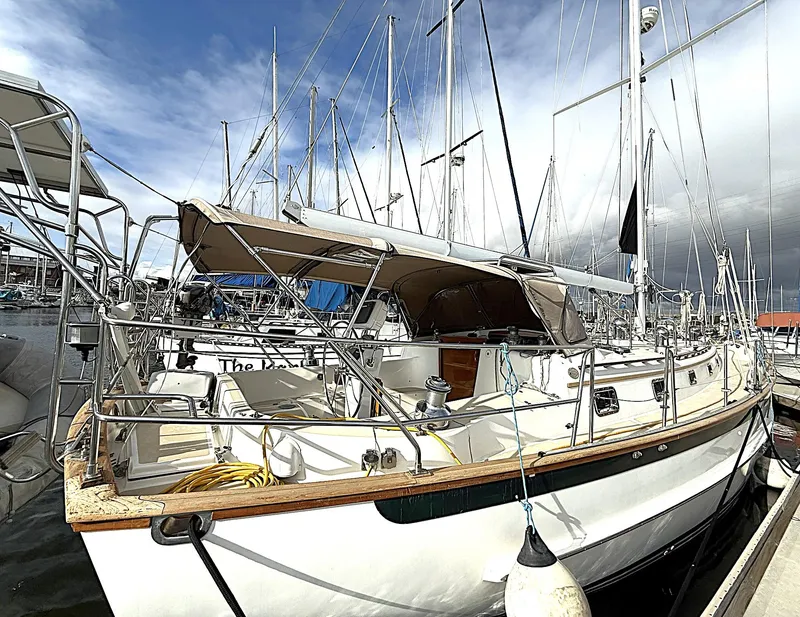 Slide: The Image of Cabo Rico Pearl Edition Anniversary Special 2000 sailboat docked at marina under cloudy sky. - 6