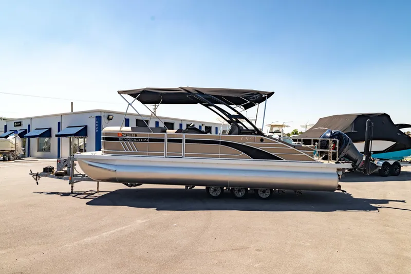 Slide: The Image of 2022 Bennington LX 24 Swingback pontoon boat parked outdoors on a sunny day. - 10