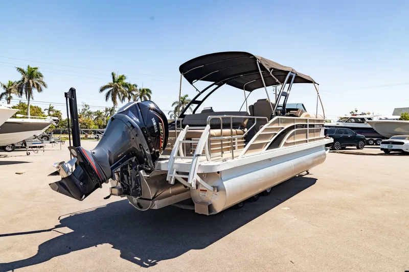 Slide: The Image of 2022 Bennington LX 24 Swingback pontoon boat with canopy and outboard motor in a sunny marina. - 14