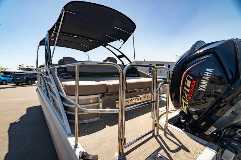 Slide: The Image of 2022 Bennington LX 24 Swingback pontoon boat with Yamaha engine, docked under clear sky. - 15