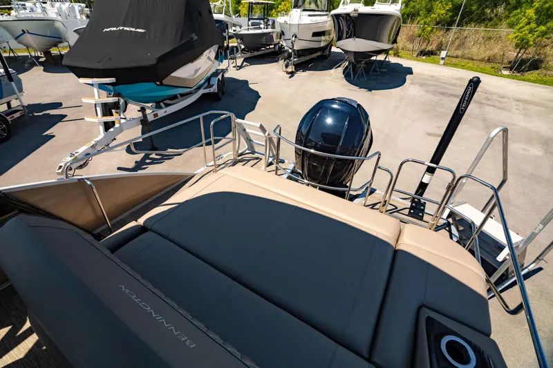 Slide: The Image of 2022 Bennington LX 24 Swingback boat with outboard motor, parked in a marina. - 17