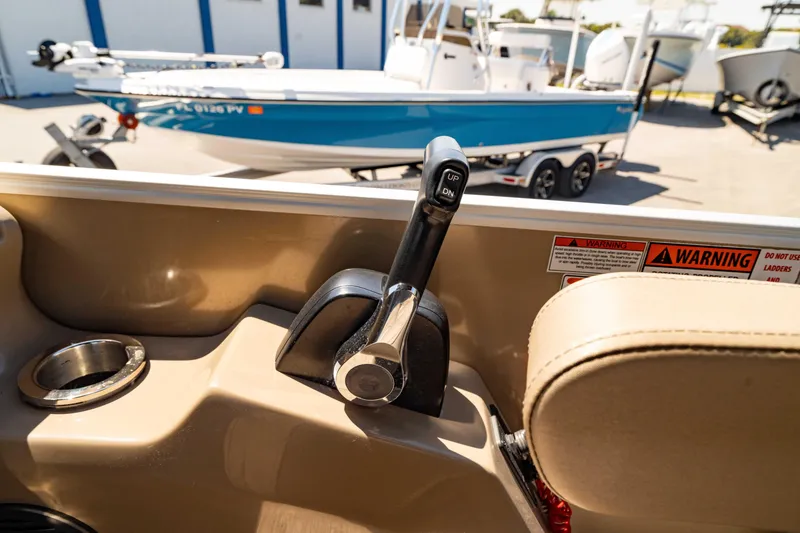 Slide: The Image of 2022 Bennington LX 24 Swingback boat throttle control with a blue boat in the background. - 24