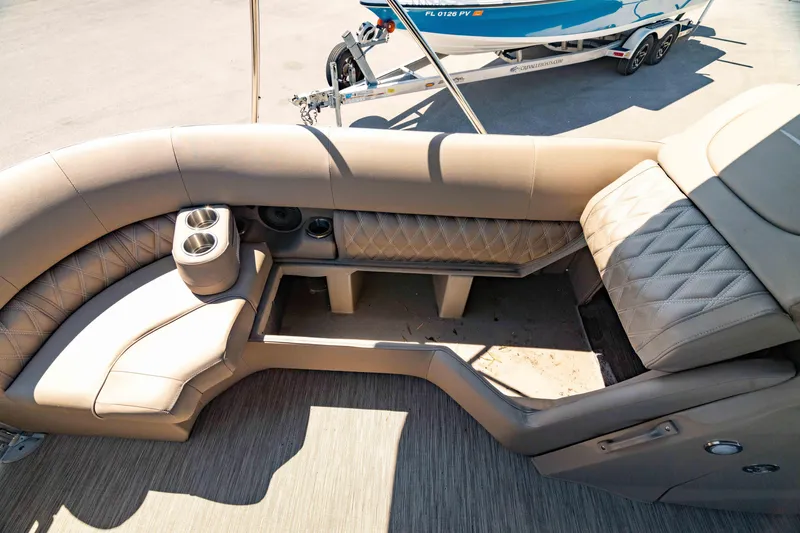 Slide: The Image of 2022 Bennington LX 24 Swingback interior with tan seating and cup holders. - 29