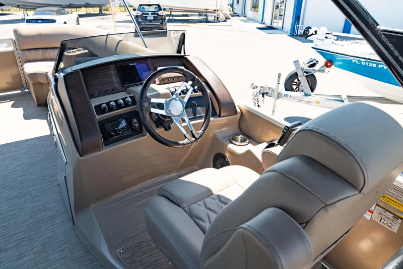 Slide: The Image of 2022 Bennington LX 24 Swingback boat interior with steering wheel and dashboard controls. - 4