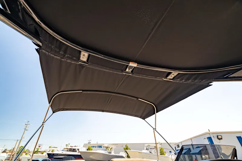 Slide: The Image of 2022 Bennington LX 24 Swingback boat canopy under clear blue sky. - 42