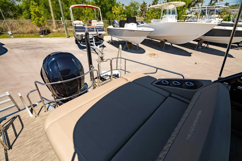 Slide: The Image of 2022 Bennington LX 24 Swingback boat with outboard motor, docked in a sunny marina. - 6